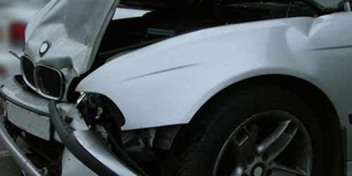 Close-up of front-end accident damage on a white car