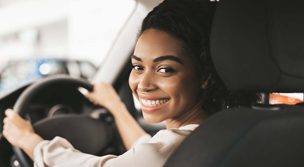 Smiling woman driving her repaired car