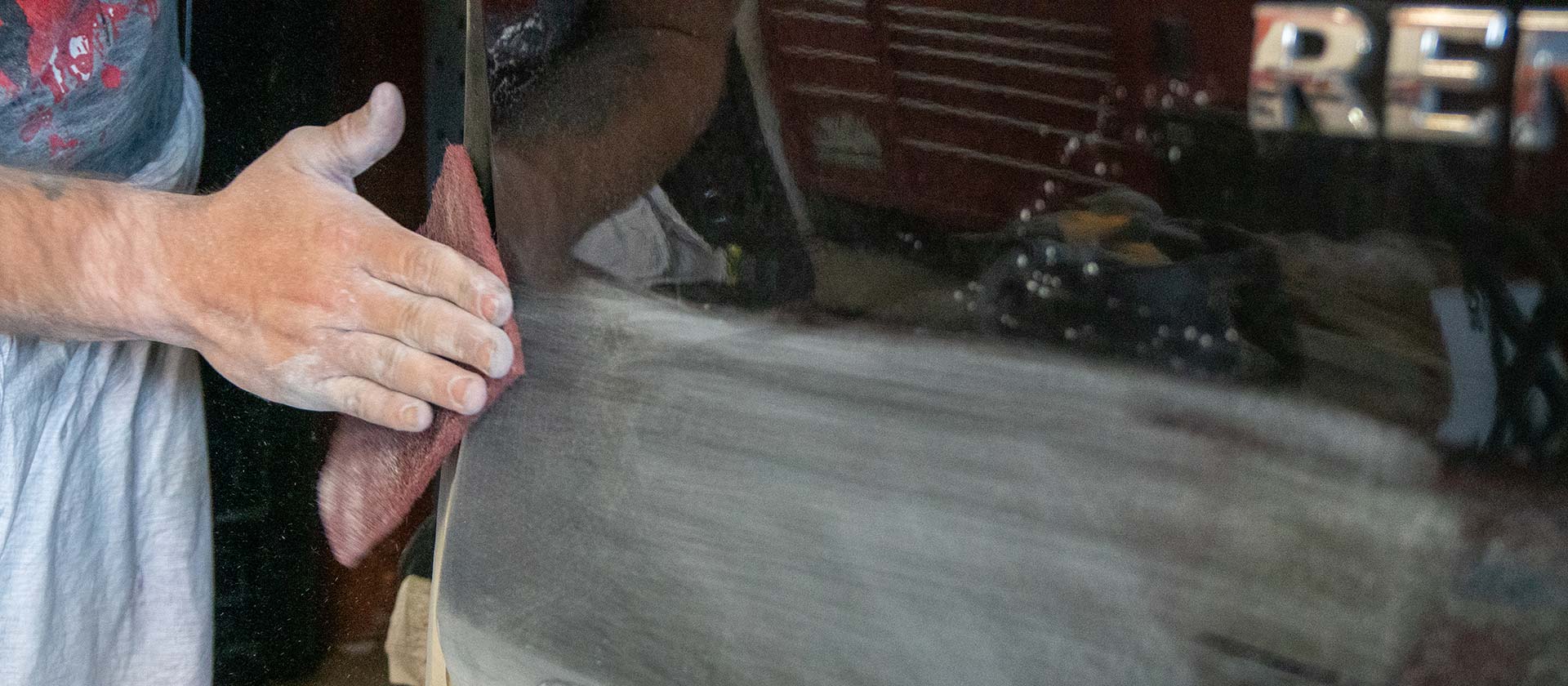Gloved hand polishing a freshly painted car panel